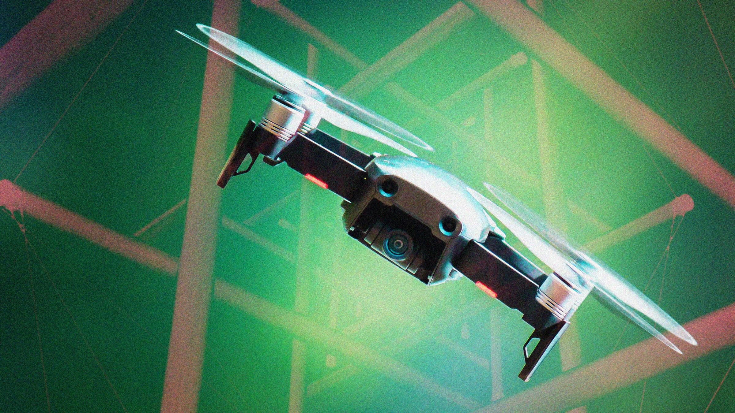 A drone with spinning propellers flying against a green, abstract background with geometric patterns.